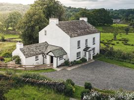 A house with a driveway and garden at Green Yew in Winster near Bowness-On-Windermere