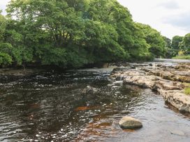 A river with rocks and trees along the shoreline at Doonalton House in Dromore West, County Sligo