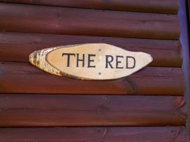 A wooden plaque with the text The Red at The Red in Llanerch Park near St Asaph