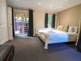 A bedroom with a bed and sliding doors at The Red in Llanerch Park near St Asaph