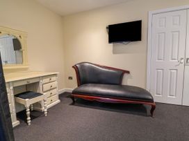A bedroom with a chaise lounge and a desk at The Red in Llanerch Park near St Asaph