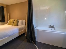 A bedroom with a bed and a bathtub at The Red in Llanerch Park near St Asaph