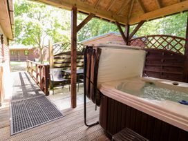 An outdoor area with a hot tub and seating at The Red in Llanerch Park near St Asaph