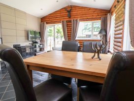 A dining room with a table and chairs at The Fallows in Llanerch Park near St Asaph