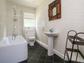 A bathroom with a bathtub, toilet, and wash basin at The Fallows in Llanerch Park near St Asaph