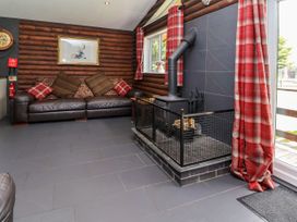 A living room with a sofa and a fireplace at The Roe in Llanerch Park near St Asaph