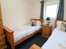 A bedroom with two single beds and a nightstand at The Roe in Llanerch Park near St Asaph