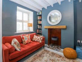 A living room with a sofa and bookshelf at East meets West Criccieth