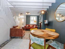 A living room with a sofa and dining table at East meets West in Criccieth