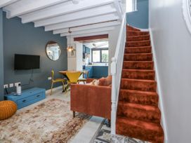 A living room with a staircase and dining area at East meets West in Criccieth