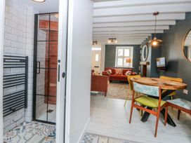 A living room with a sofa and dining area at East meets West in Criccieth