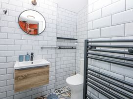 A bathroom with a sink, toilet, and mirror at East meets West in Criccieth