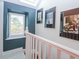 A hallway with photos on the wall at East meets West Criccieth