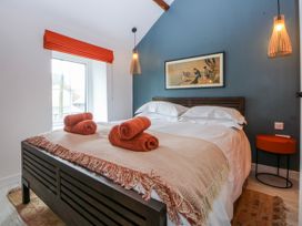 A bedroom with a bed and side table at East meets West in Criccieth