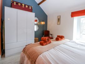 A bedroom with a bed and wardrobe at East meets West in Criccieth