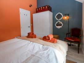 A bedroom with a bed and towels at East meets West in Criccieth