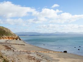 A beach view with water and mountains at East meets West Criccieth