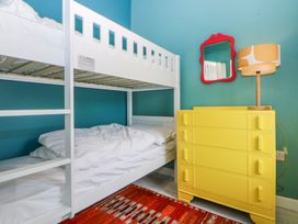 A bedroom with a bunk bed and yellow dresser at East meets West Criccieth
