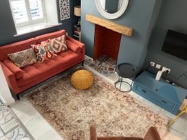 A living room with a sofa and fireplace at East meets West in Criccieth