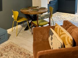 A dining area with a round table and dining chairs at East meets West Criccieth