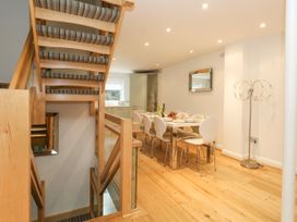 A dining area with a table set for six next to a wooden staircase with striped carpet at 5 Red Sails in Sandbanks