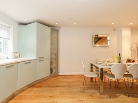 A kitchen and dining area with a table set for a meal and cabinets along one wall at 5 Red Sails in Sandbanks