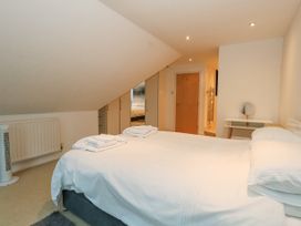 A bedroom with a bed two folded towels wardrobe and a dressing table at 5 Red Sails in Sandbanks