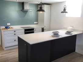 A kitchen with an island and stove at Fishermans Locker in West Bay