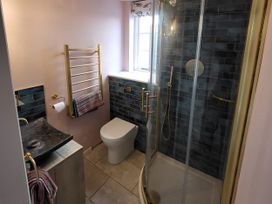 A bathroom with a shower, toilet, and sink at Fishermans Locker in West Bay