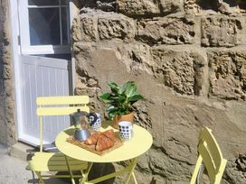 An outdoor seating area with a table and chairs at Fishermans Locker in West Bay