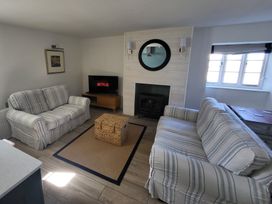 A living room with a tv and sofas at Fishermans Locker in West Bay