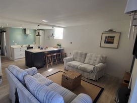 A living room with a sofa and kitchen island at Fishermans Locker in West Bay