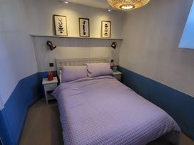 A bedroom with a bed and wall art at Fishermans Locker in West Bay
