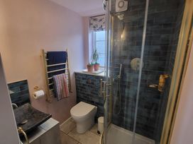 A bathroom with a shower, toilet, and sink at Fishermans Locker in West Bay