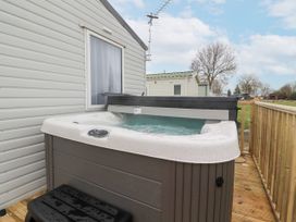 An outdoor hot tub on a wooden deck next to a mobile home at Giorgio in Warton Bank near Warton Lancashire