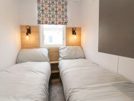 A bedroom with two single beds and a window with patterned blinds at Giorgio Warton Bank near Warton Lancashire
