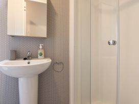 A bathroom with a pedestal sink a mirror cabinet and a glass shower enclosure at Giorgio in Warton Bank near Warton Lancashire