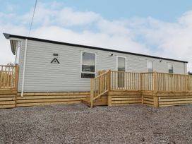 A mobile home with wooden deck and stairs on a gravel surface at Giorgio in Warton Bank near Warton Lancashire