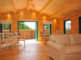 A living room with a wooden table and chairs at Owl Lodge in Menheniot
