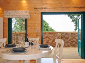A dining room with a table set for four at Owl Lodge in Menheniot
