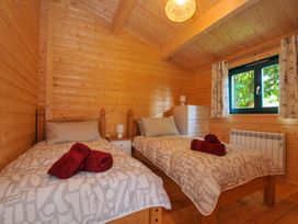 A bedroom with two beds and a chest of drawers at Owl Lodge in Menheniot