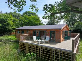 A house with a deck and chairs at Owl Lodge Menheniot