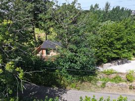 A house surrounded by trees and gravel at Owl Lodge in Menheniot