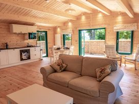 A living room with kitchen and dining area at Owl Lodge in Menheniot