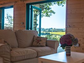 A living room with a sofa and a table at Owl Lodge in Menheniot
