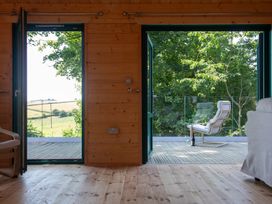 An indoor space with doors opening to an outdoor area at Owl Lodge Menheniot