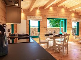 A kitchen with a dining table and chairs at Owl Lodge Menheniot