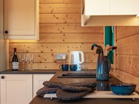 A kitchen with a wine bottle and glasses at Owl Lodge in Menheniot