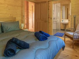 A bedroom with a bed and towels arranged at Owl Lodge in Menheniot