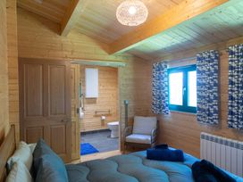 A bedroom with a bed and ensuite bathroom at Owl Lodge Menheniot